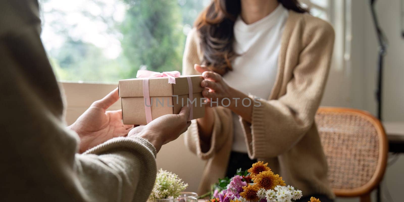 Romantic young asian couple embracing giving present in living room at home. Fall in love. Valentine concept by nateemee
