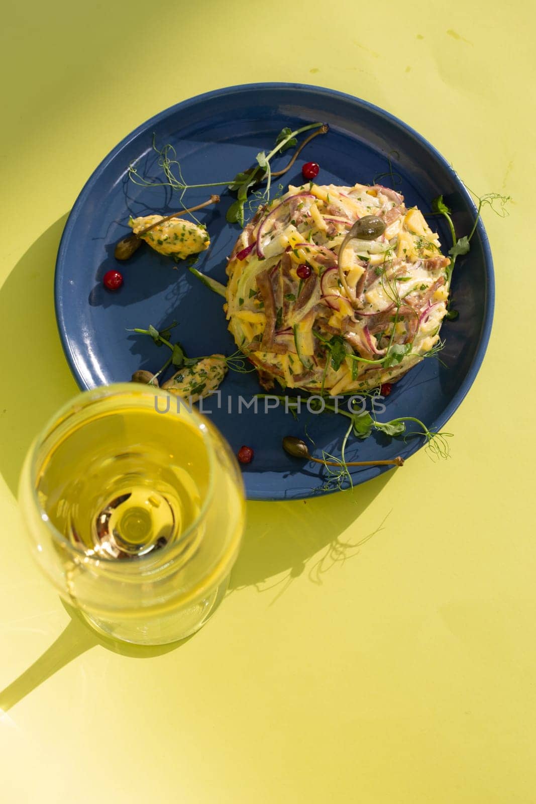 Seafood salad with succulent shrimp, crab, avocado, and light mayo on a blue plate. Served with white wine on a yellow background. Perfect for a light and satisfying meal.