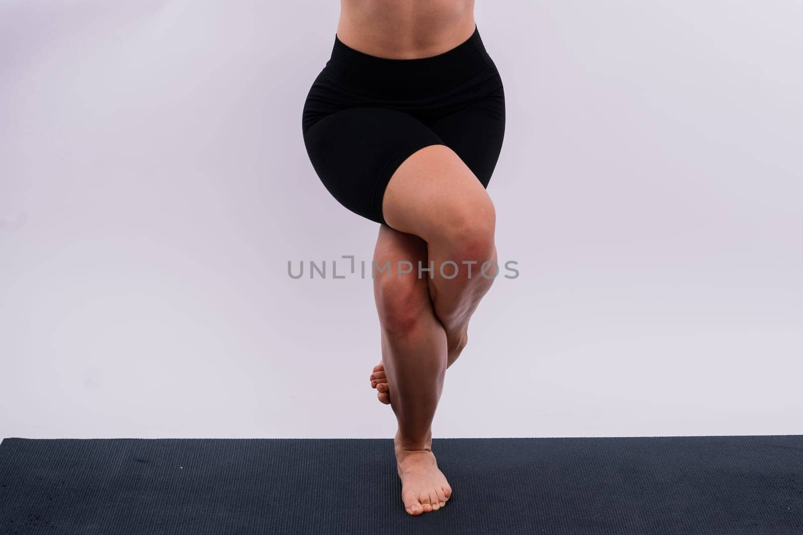 Beautiful female in yoga studio. A woman doing yoga. Lady in a top.