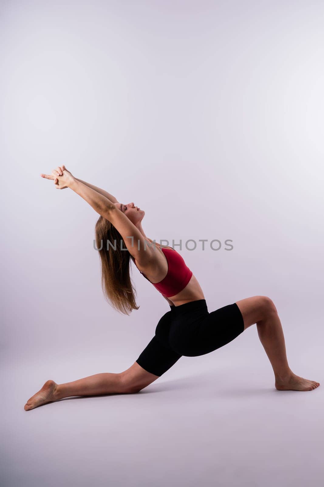 Beautiful female in yoga studio. A woman doing a yoga. Lady in a top. by Zelenin