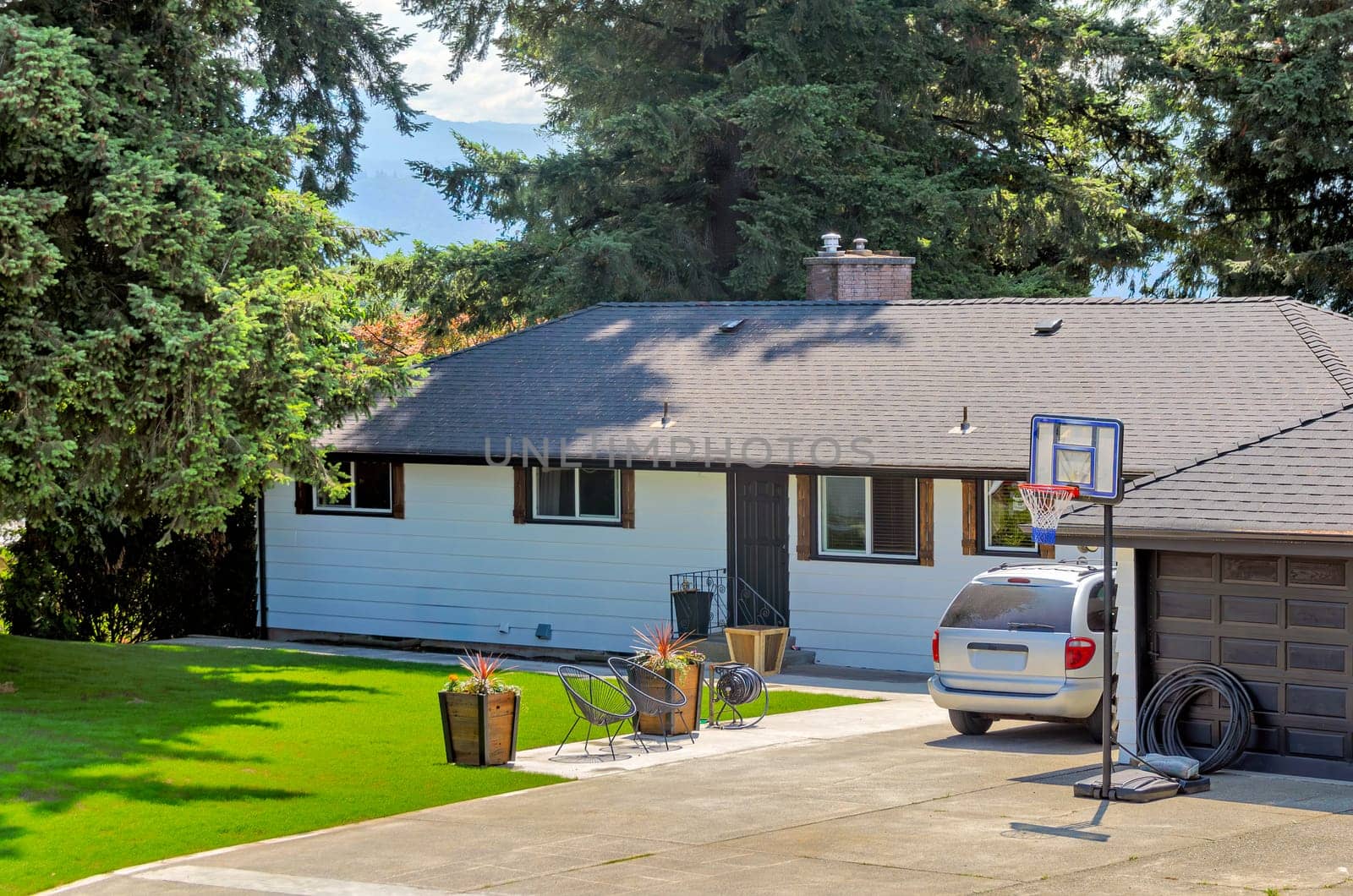 Average residential house with front yard lawn and car parked on the driveway by Imagenet