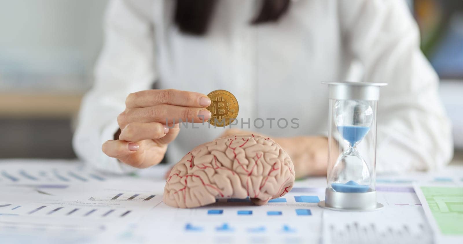 Business woman holding bitcoin coin in front of brain mockup and hourglass closeup by kuprevich