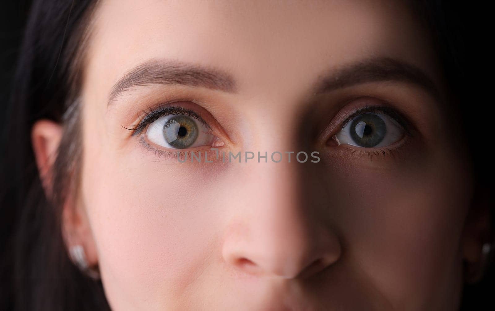 Closeup of female eyes with permanent eyebrow makeup and false eyelashes. Eyelid skin care concept