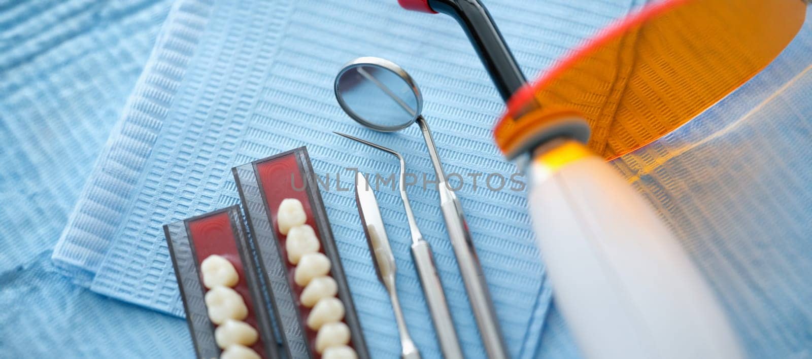 Dental instruments and dentures lying on sterile medical napkin in clinic closeup by kuprevich