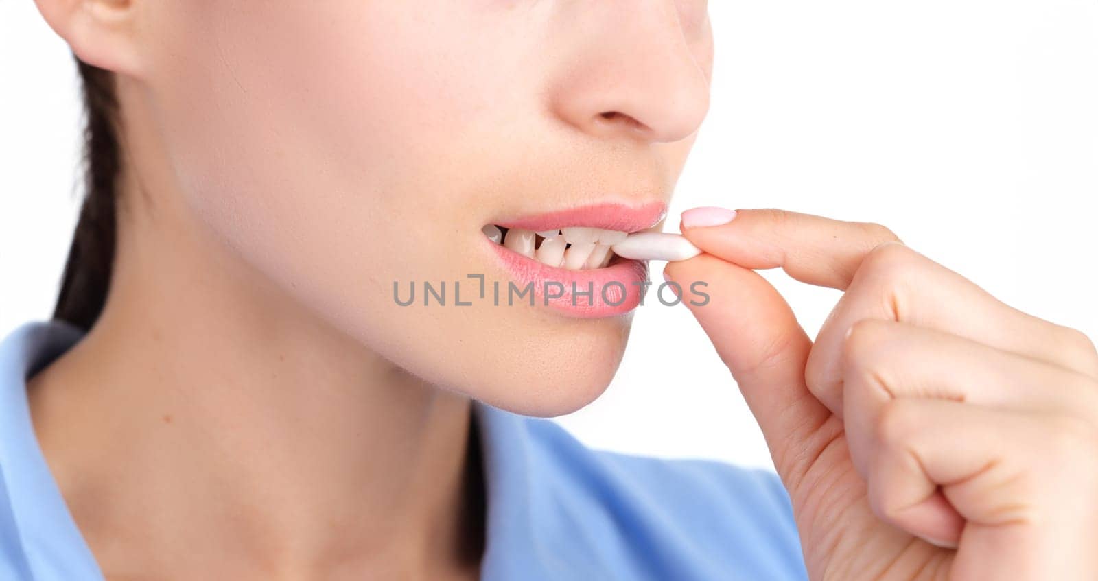 Woman putting chewing gum in her mouth with hand closeup by kuprevich