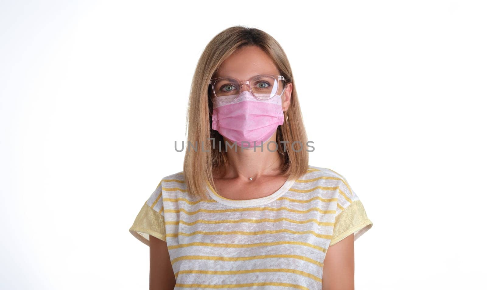 Portrait of young woman in pink protective medical mask and glasses for vision. Prevention of covid 19 infection concept