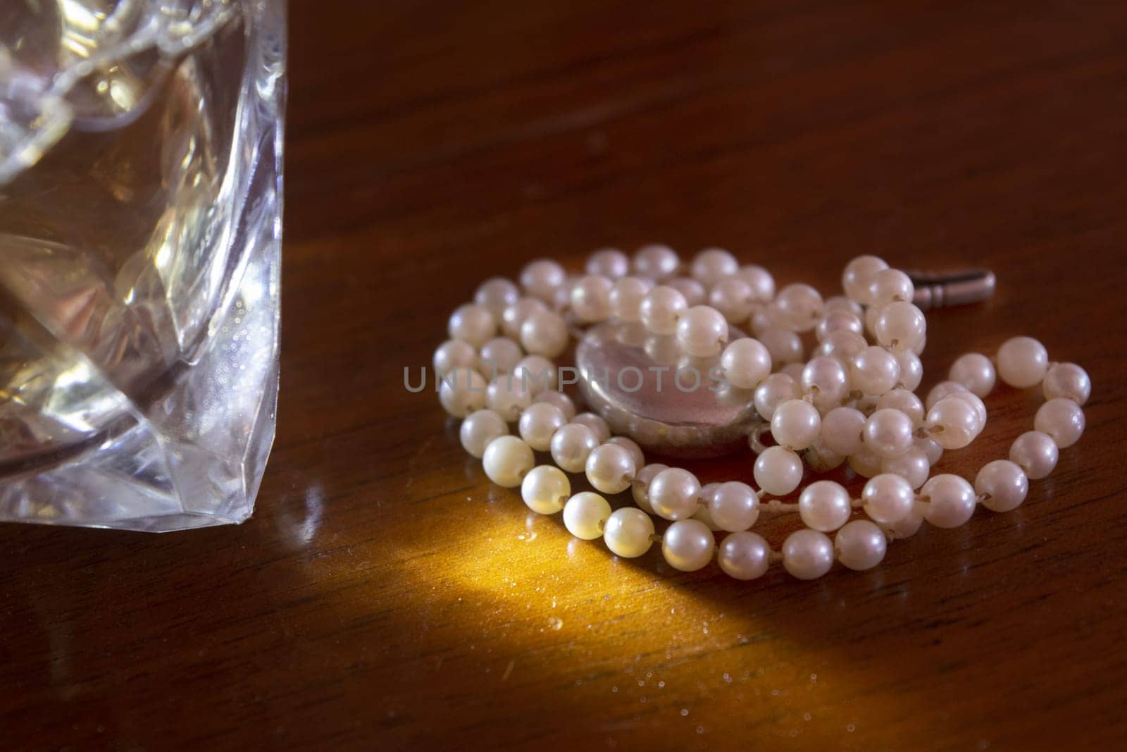 pearl necklace next to a precious stone with light reflections