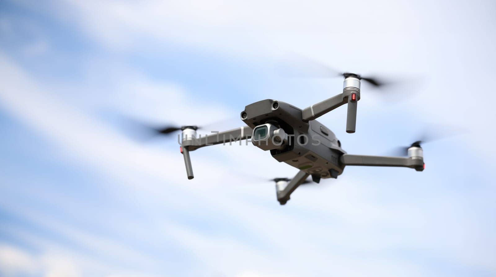 Close-up of digital camera on drone with remote control. Modern copter flying in sky. Shooting propeller option. Technology and innovation concept