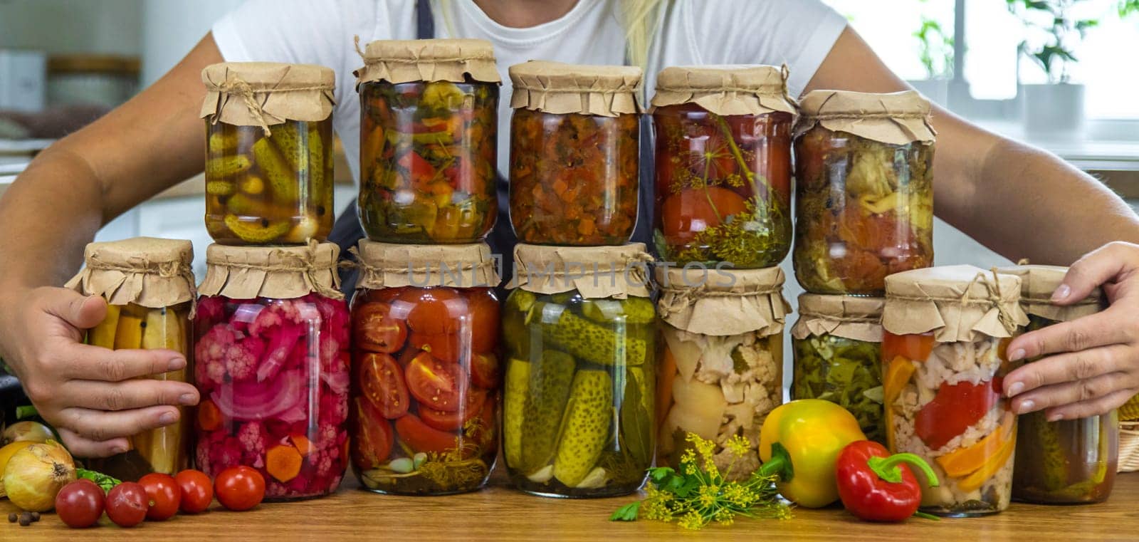 Woman canning vegetables in jars in the kitchen. Selective focus. Food.