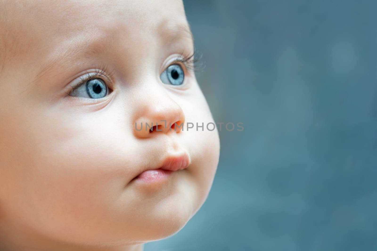 Close up of a baby face with blue eyes by Mariakray