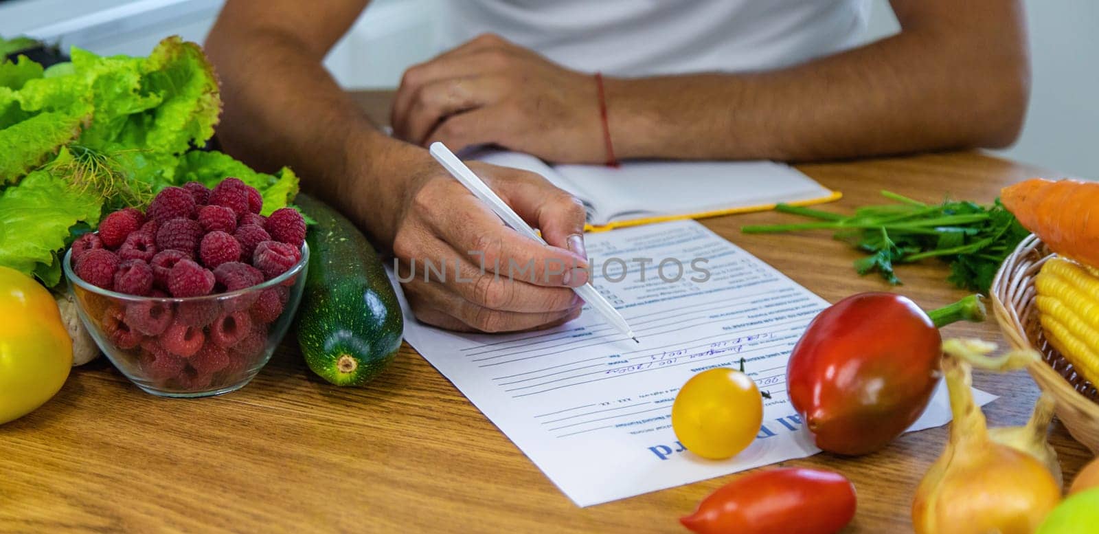 A nutritionist writes a nutrition plan. Selective focus. by yanadjana