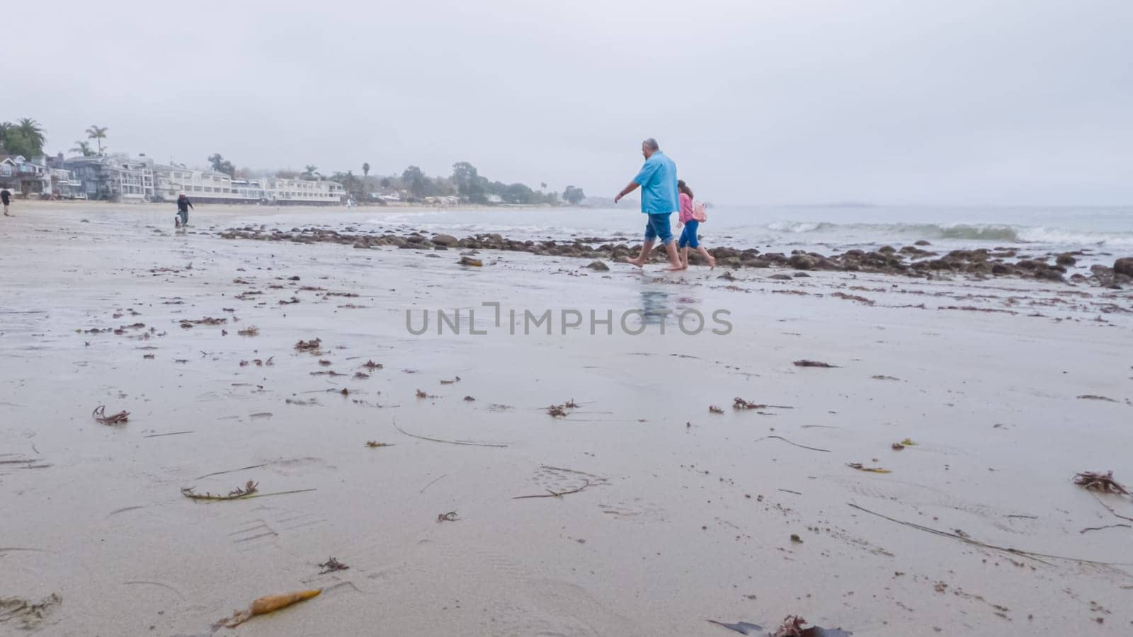 Walking along the shore of Miramar Beach, California, the overcast winter sky creates a tranquil and reflective atmosphere.