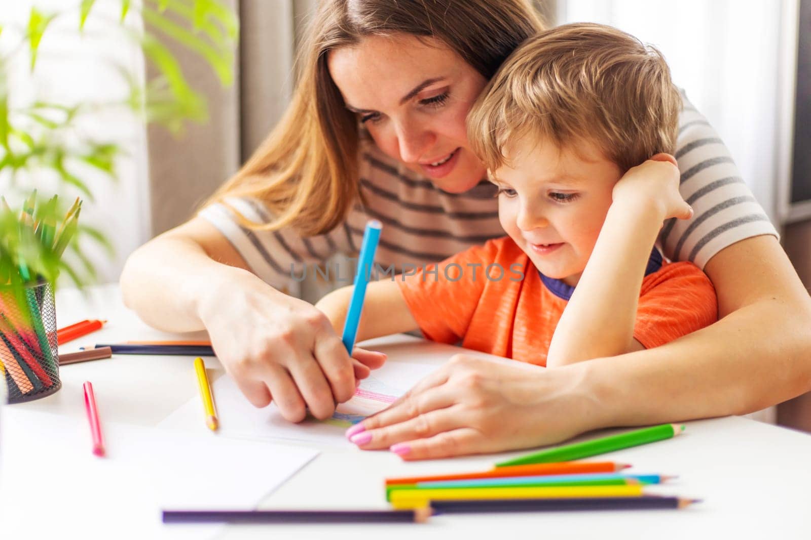 Mother Helping Child with Drawing at Home by andreyz