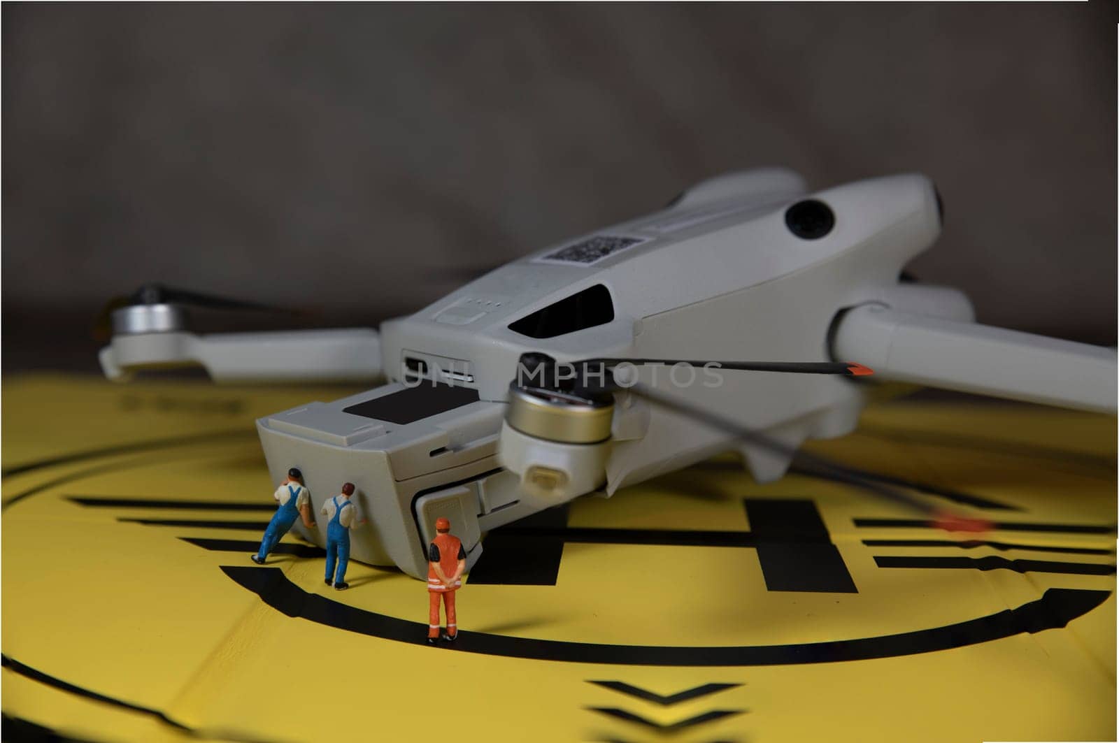 miniature figures replacing the battery of a drone by compuinfoto
