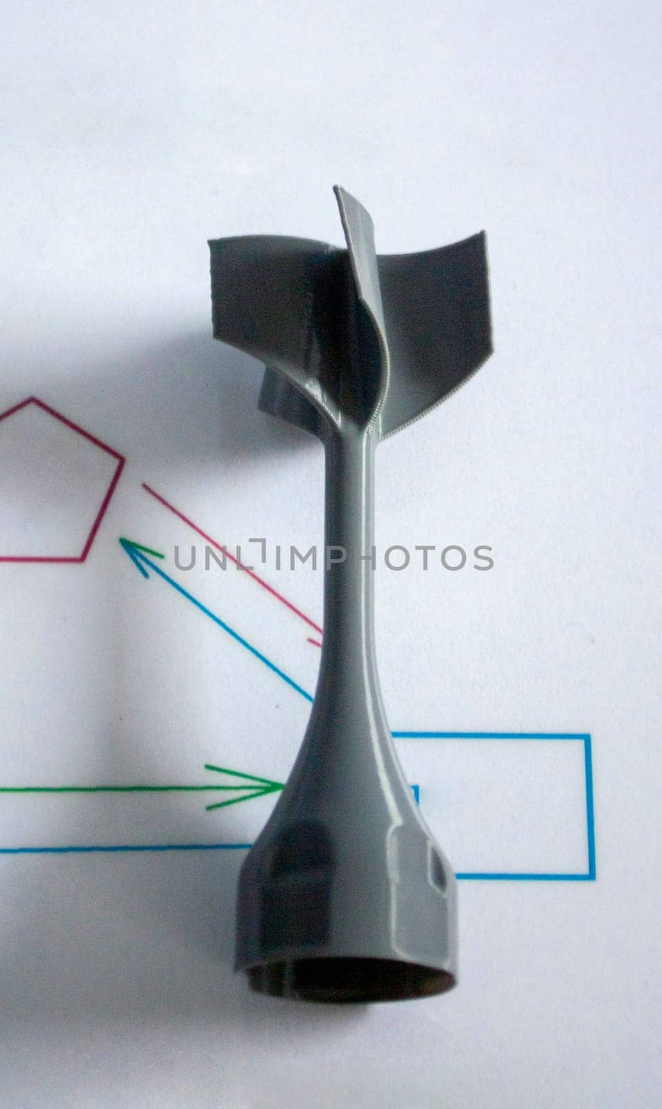 Prototype model of rocket bomb tip printed on 3D printer. Small models of tail fins, tail cone printed on 3D printer from molten plastic on table. New modern innovation printing technology