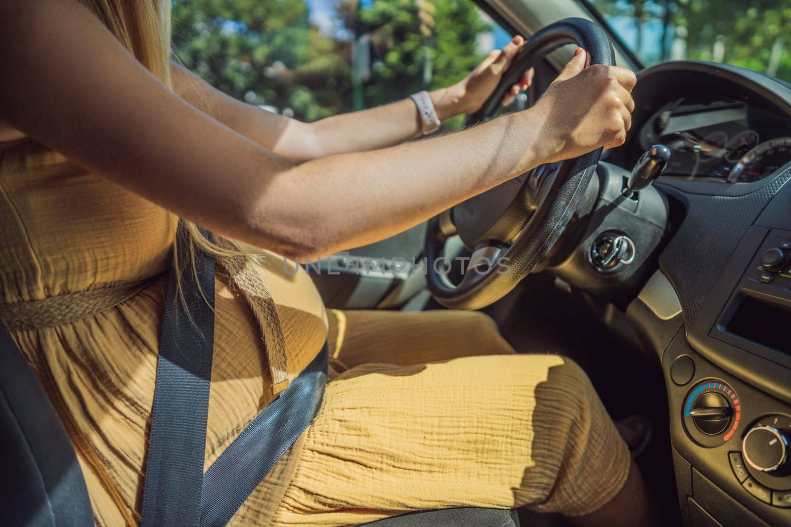 Pregnant woman driving with safety belt on in the car. Confident and capable, a pregnant woman takes the wheel, driving with care and determination as she navigates the journey of motherhood.