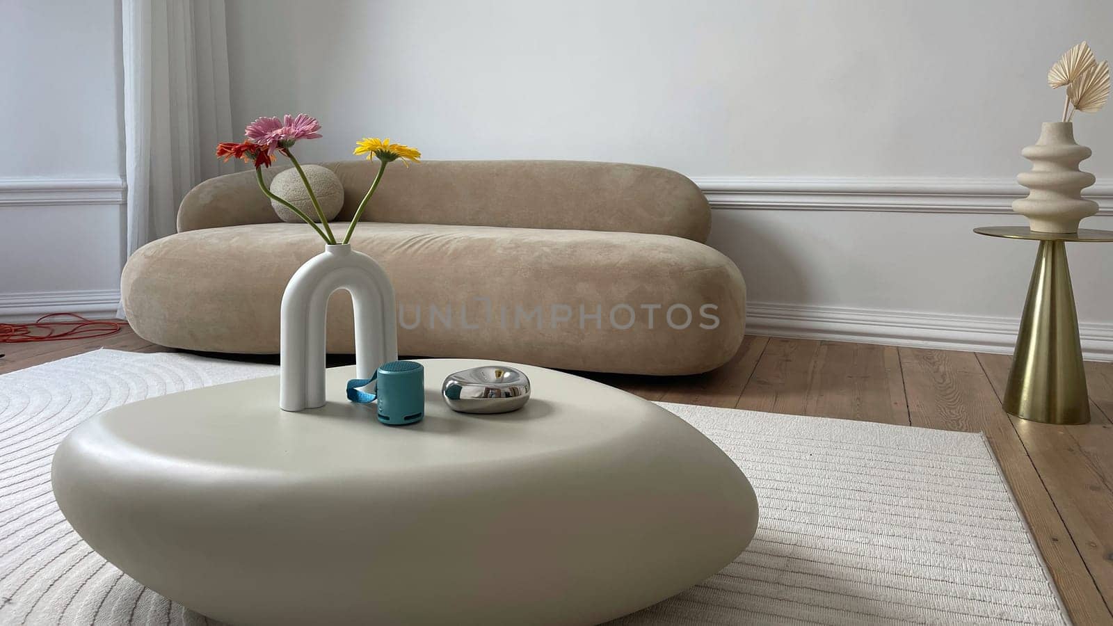 Gerbera flowers and a cup of coffee on a table in a beige bedroom. High quality photo