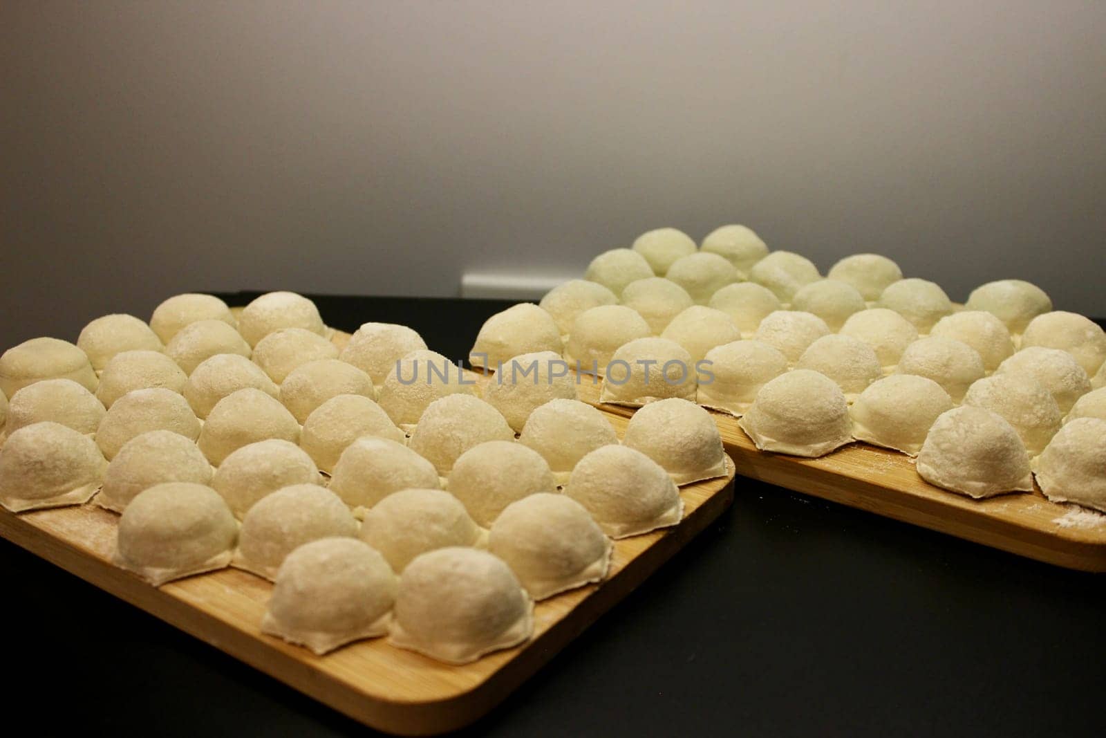 Dumplings made of dough and minced meat are stuck on the board. High quality photo