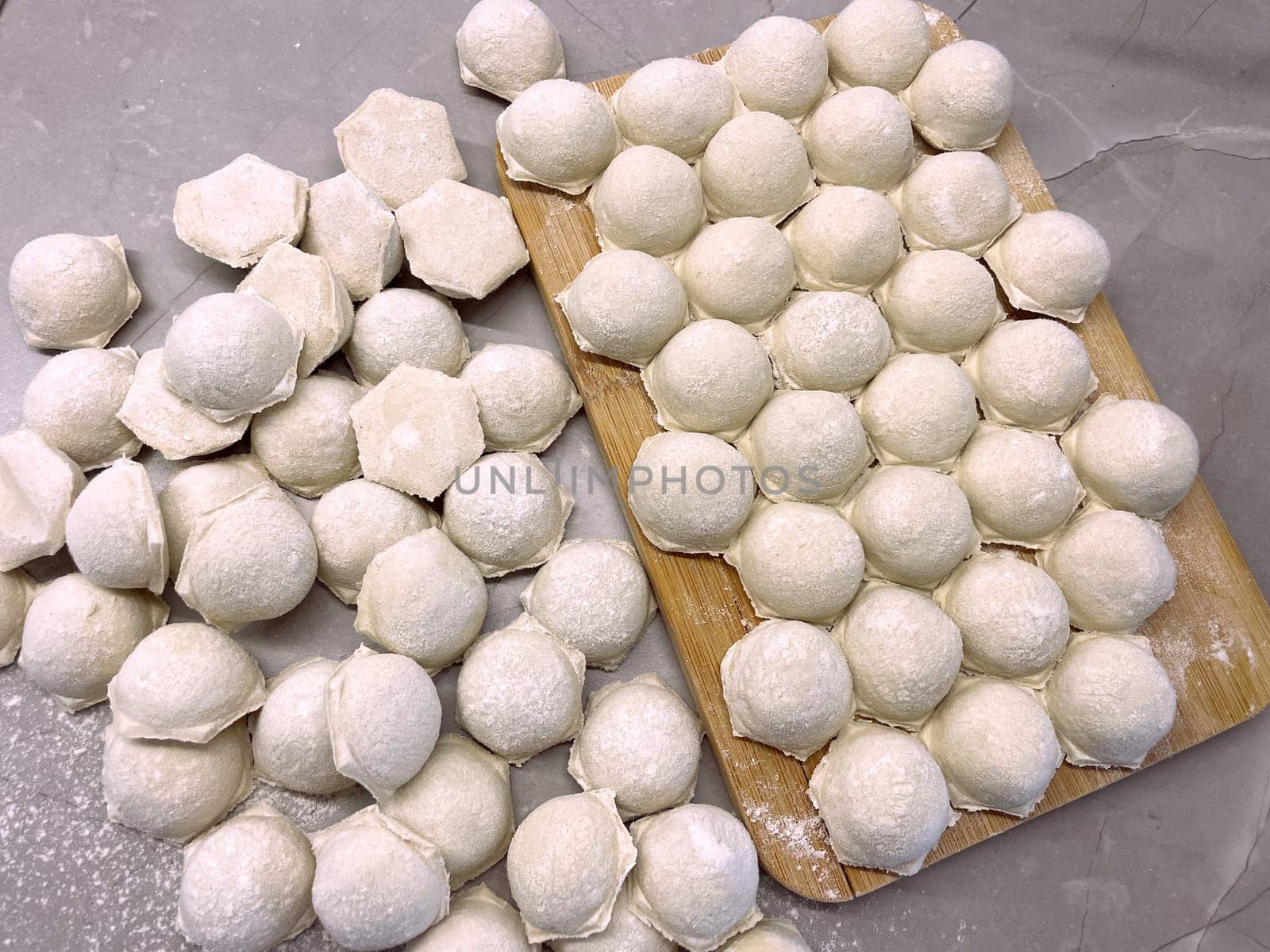 Dumplings made of dough and minced meat are stuck on the board. High quality photo