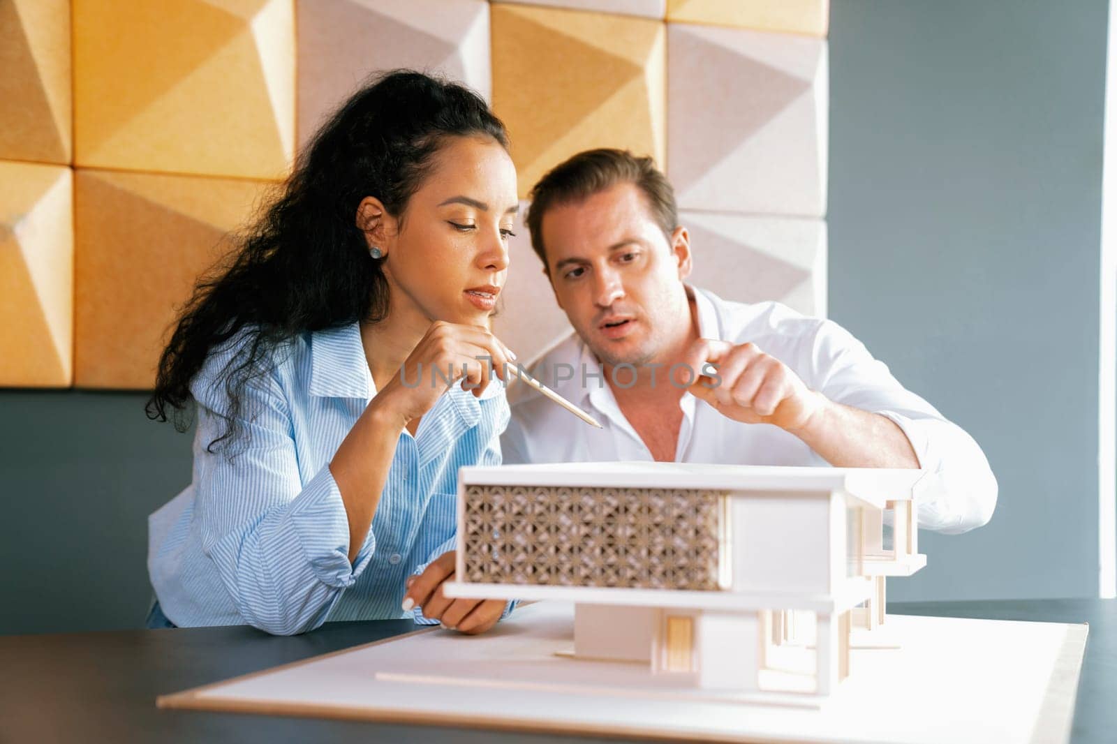 Cooperative skilled architect engineer team discussion about house construction while measuring house model at modern office. Team work, working together and creative design concept. Manipulator.