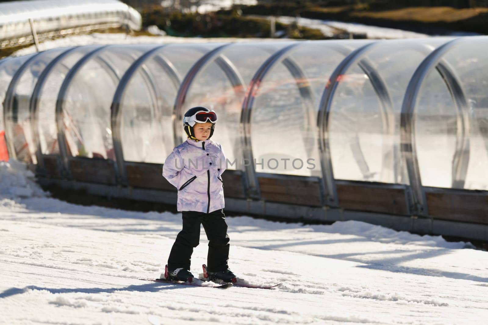 A six-year-old girl learns to ski near lift tunnel