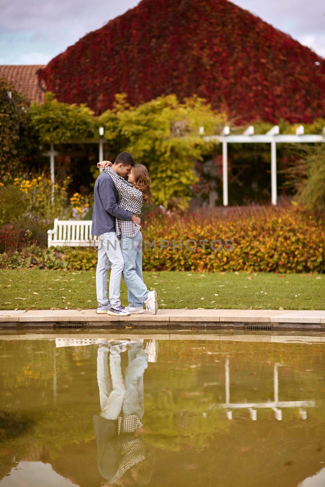 Young couple kissing and rejoices at the lake. lovely young couple kissing outdoors in autumn. Loving couple walking in nature. Autumn mood. Happy man and woman hugging and kissing in autumn. Love. Fashionable couple outdoors. Fashion, people and lifestyle. Stylish couple in autumn outfit. by Andrii_Ko