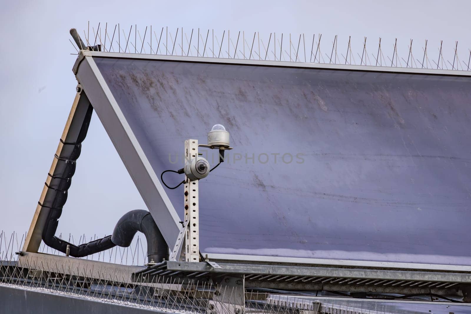 Solar modules with spikes to repel pigeons on a house roof by astrosoft