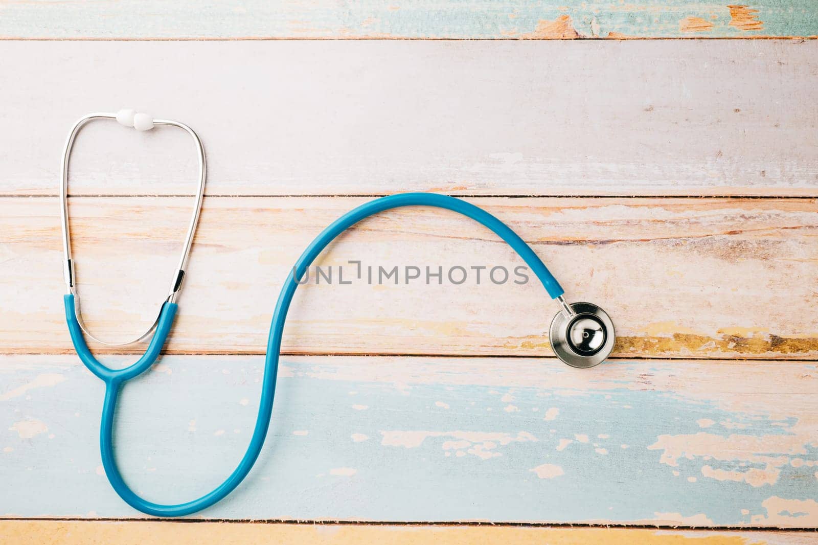 Top view blue medical stethoscope on wooden background with copy space for you text, Doctor equipment, healthcare and medical, Doctor Day and World cancer day Concept
