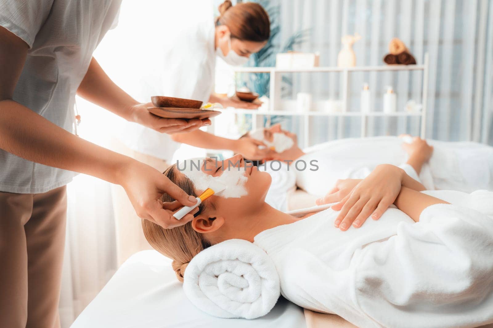 Serene ambiance of spa salon, couple indulges in rejuvenating with luxurious face cream massage with modern daylight. Facial skin treatment and beauty care concept. Quiescent