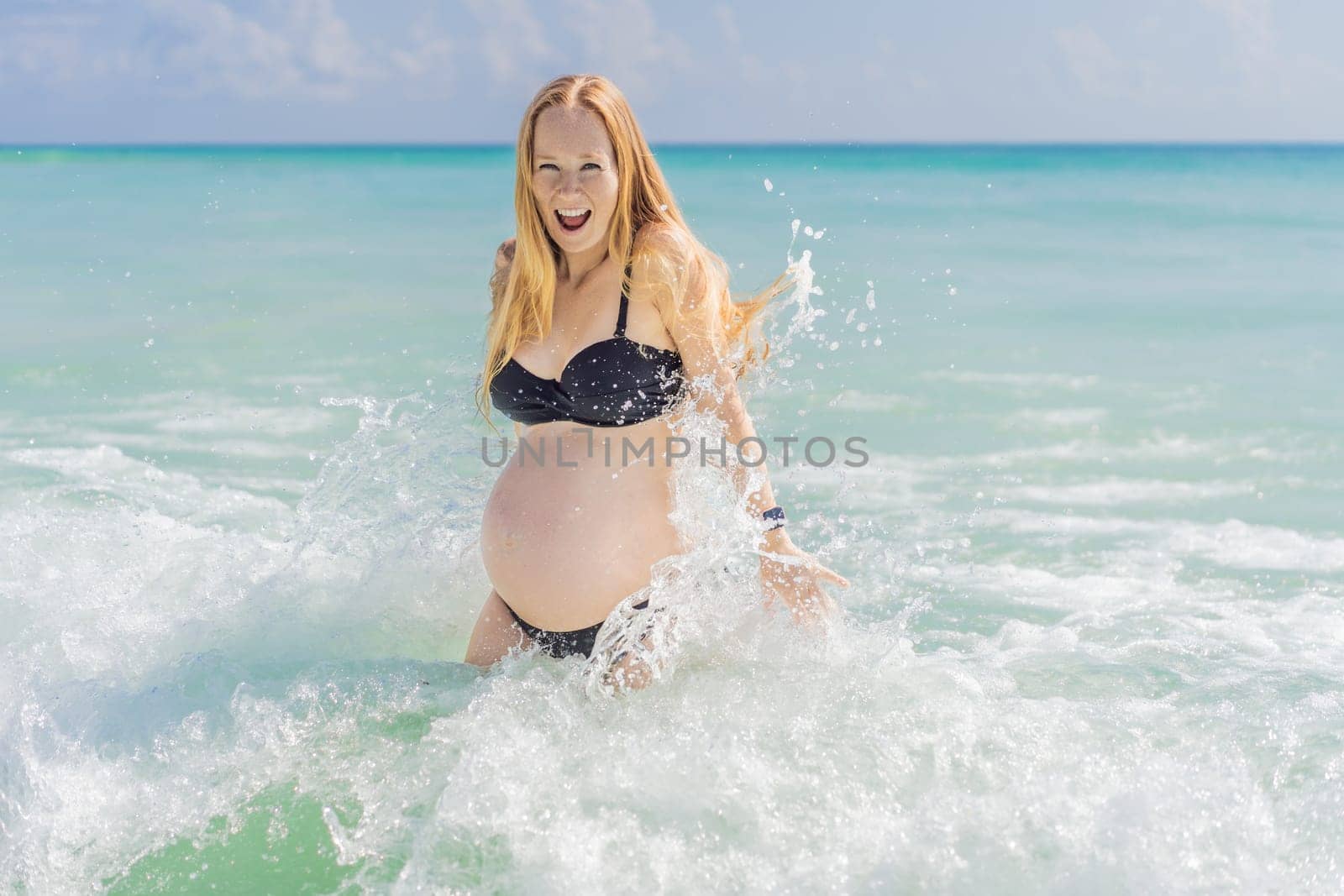 In the idyllic embrace of the Caribbean Sea, a pregnant woman finds bliss, savoring the warmth and serenity of the tropical waters during her pregnancy by galitskaya
