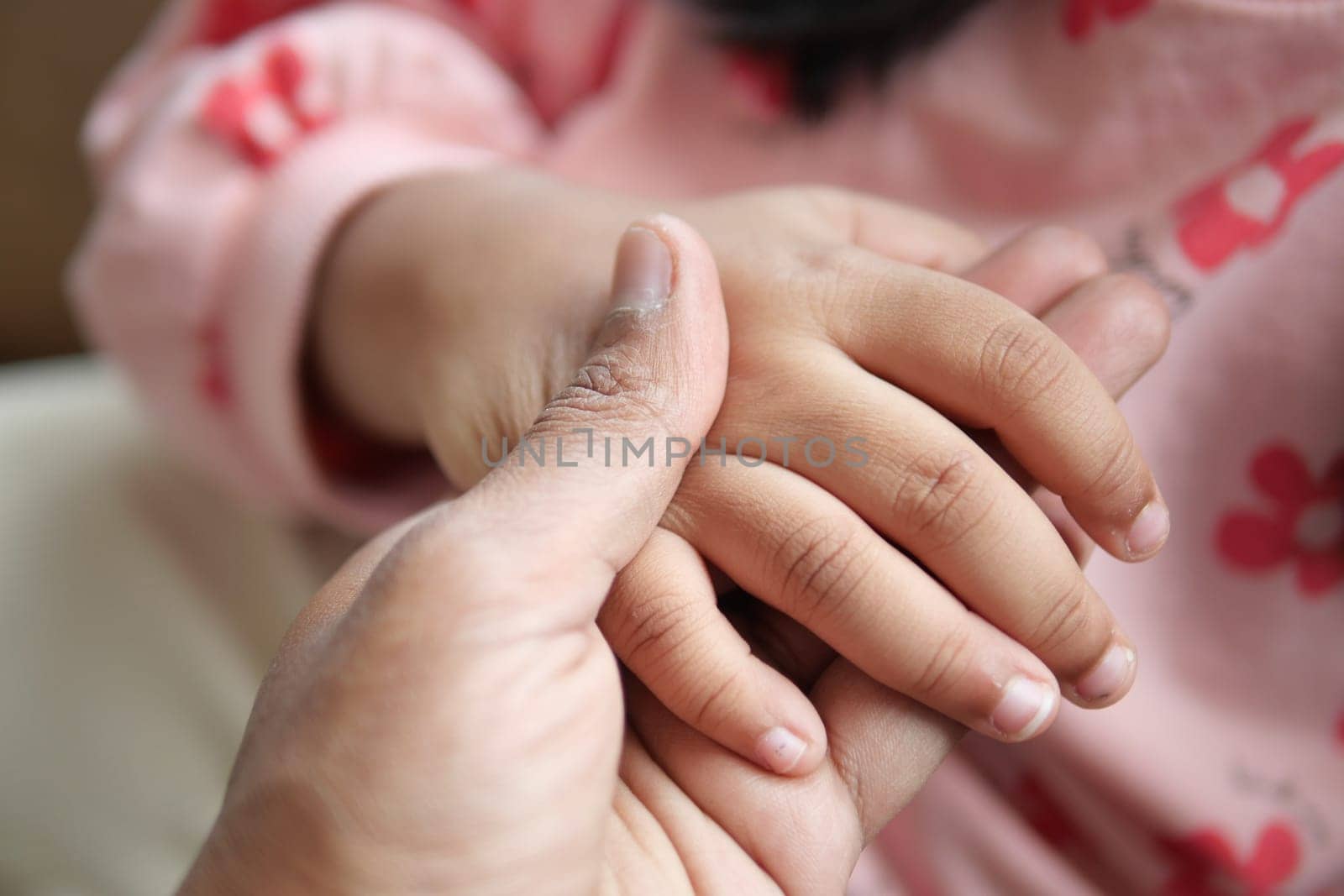 father holding hand of baby child, close up