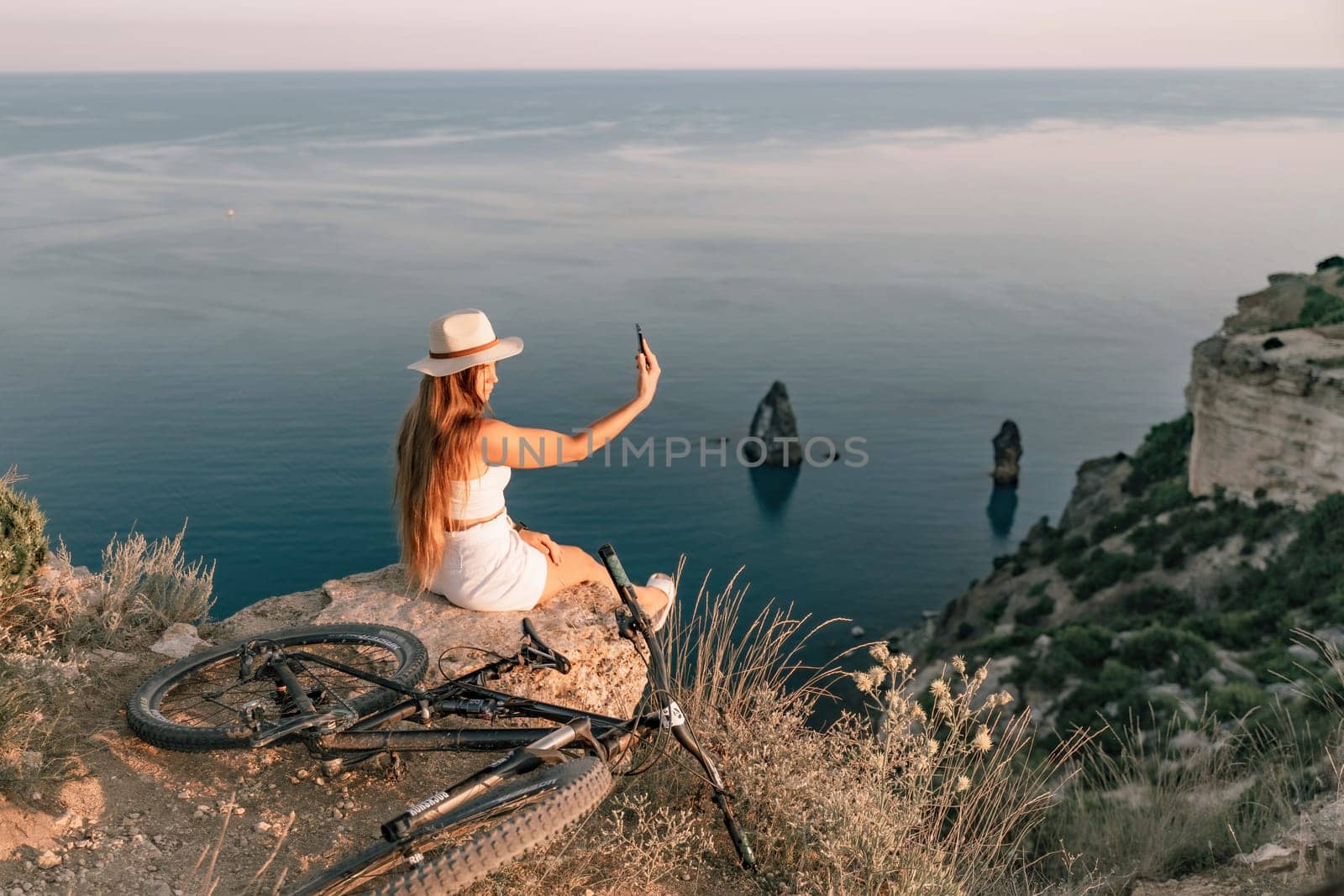 Selfie woman in cap and tank top making selfie shot mobile phone post photo social network outdoors on sea background beach people vacation lifestyle travel concept. by Matiunina