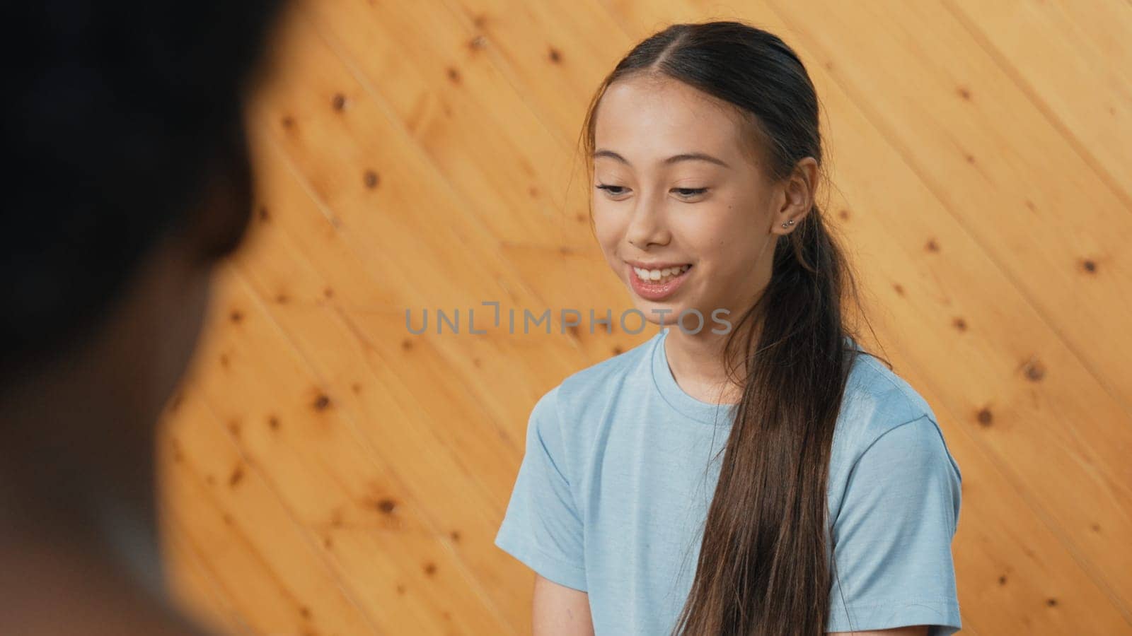 Young smart girl discussion about problem while sitting in circle. Skilled happy highschool student talking, brainstorming, sharing idea while diverse children listen and give comment. Edification.