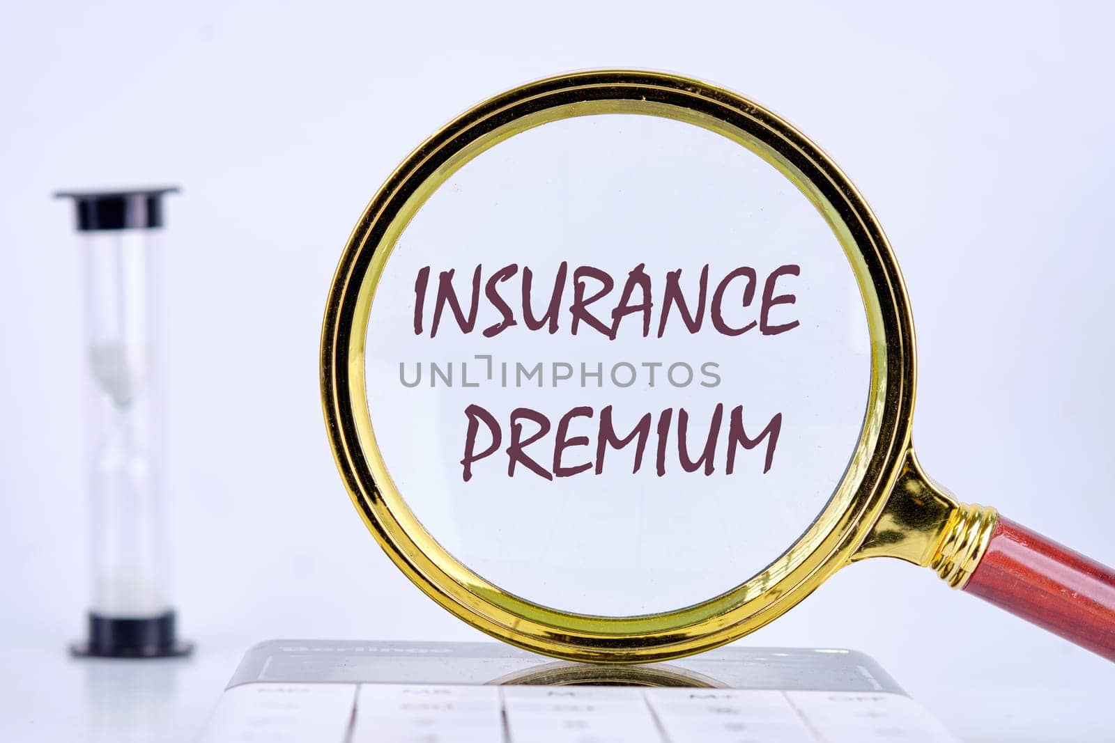 Business concept. text INSURANCE PREMIUM written through a magnifying glass on a gray background. Business concept