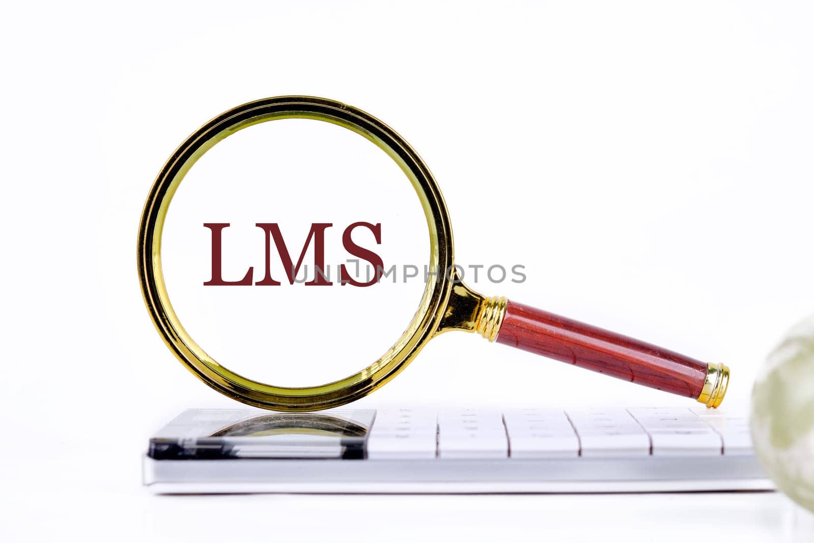 Abbreviation of Learning management system, Word LMS writing through a magnifying glass on a calculator on a light background. Business development concept