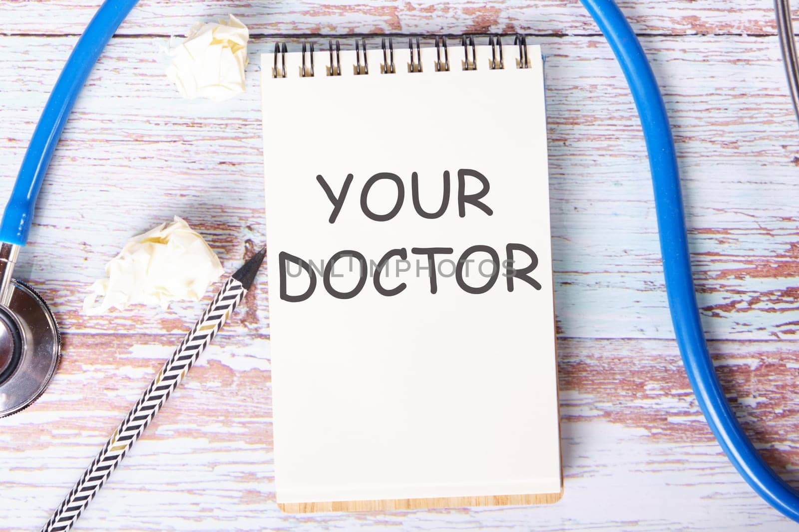 YOUR DOCTOR text is written on a notebook that lies on old vintage boards