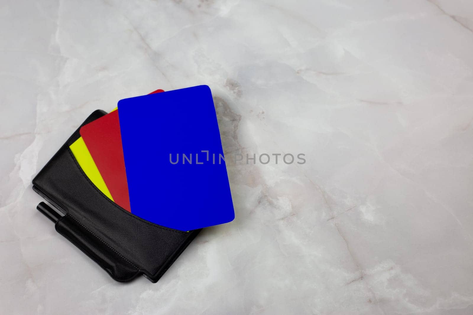 Three football cards in notebook for the chest pocket of football referee lie on white table