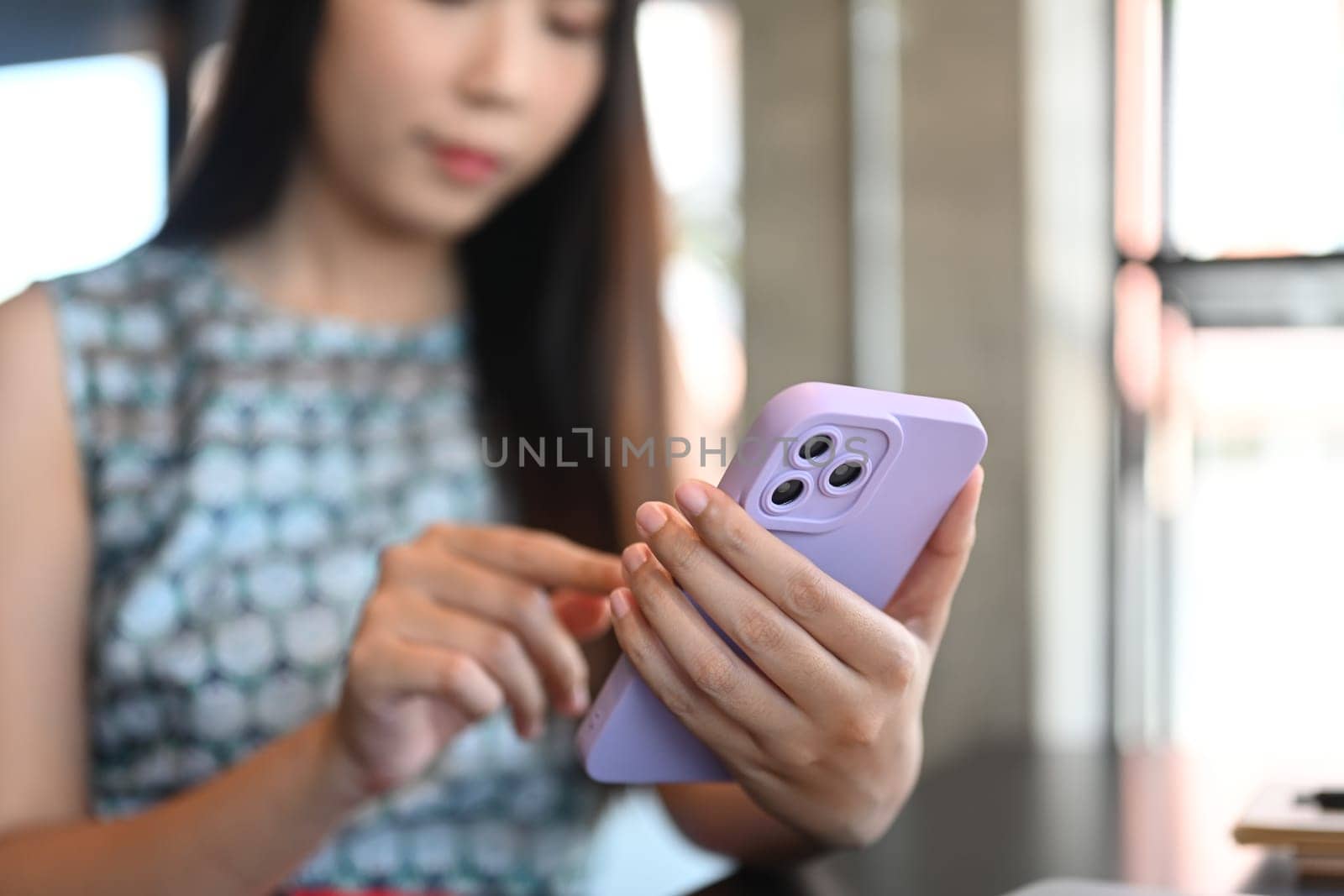 Young businesswoman typing message, chatting online on mobile phone.