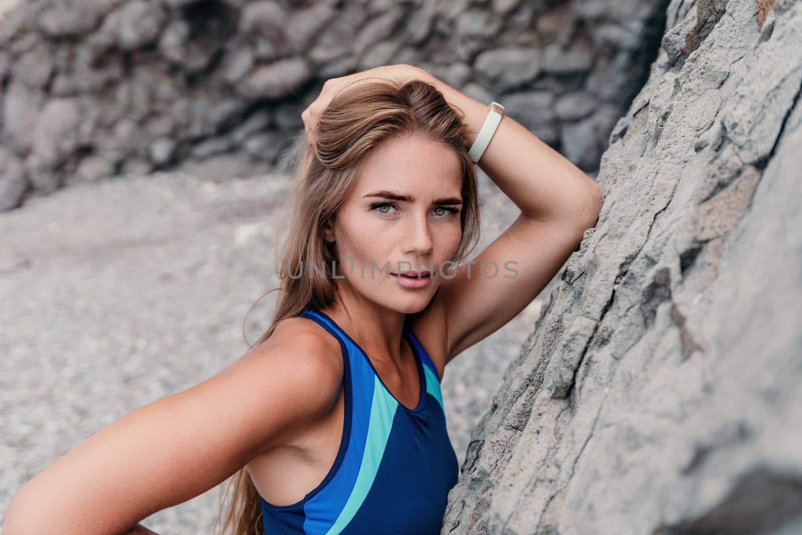 Woman travel sea. Young Happy woman in a long red dress posing on a beach near the sea on background of volcanic rocks, like in Iceland, sharing travel adventure journey