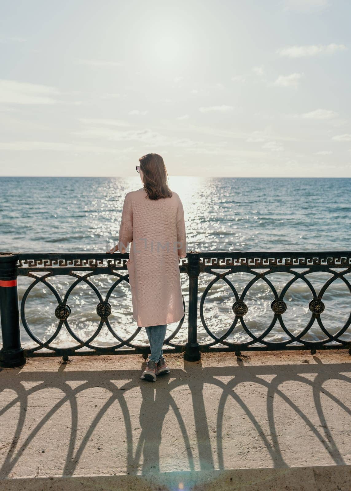 Woman summer travel sea. Happy tourist enjoy taking picture outdoors for memories. Carefree woman traveler posing on beach at sea on sunset, sharing travel adventure journey. Holiday vacation concept. by panophotograph