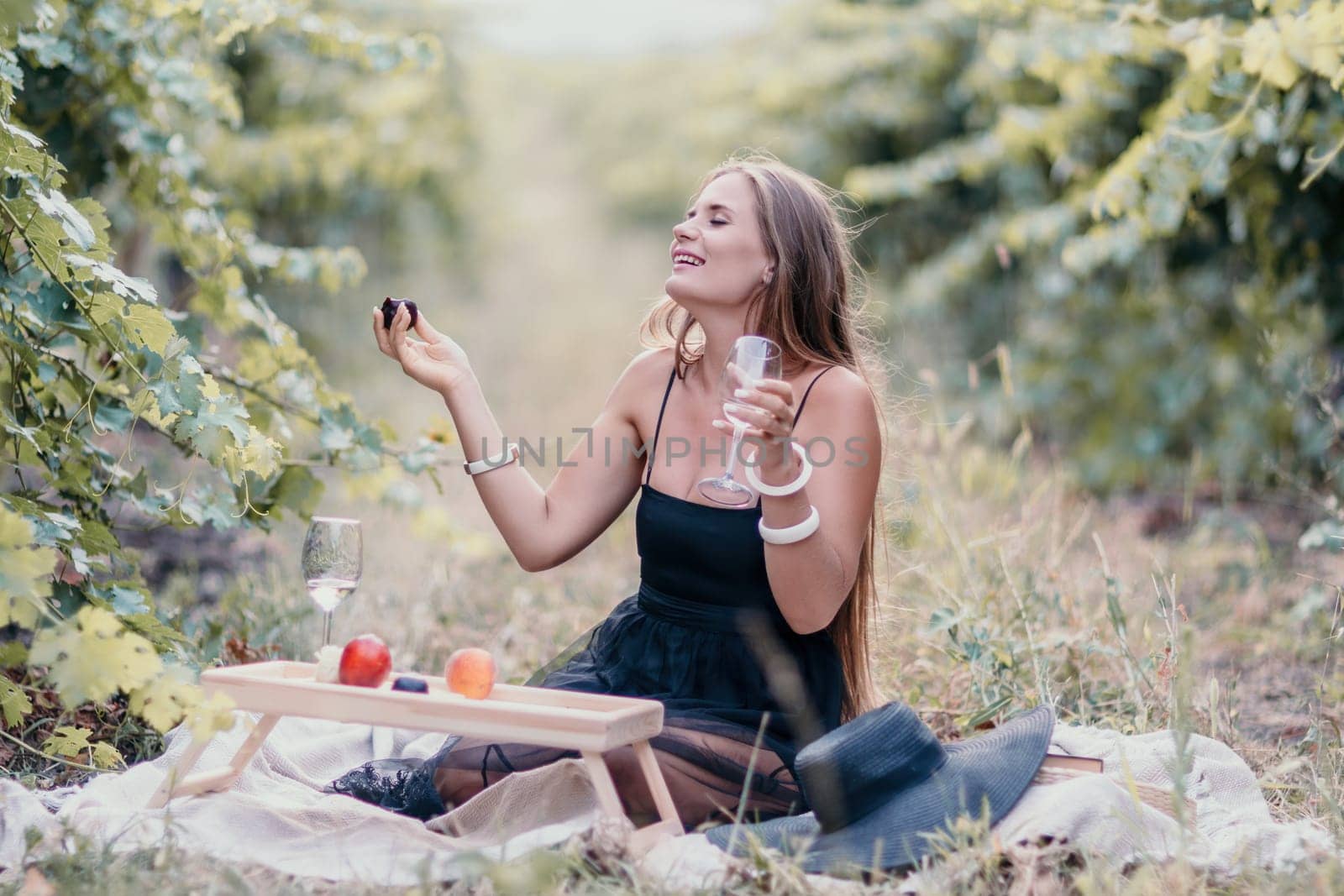Picnic and wine tasting at sunset in the hills of Italy, Tuscany. Vineyards and open nature in the summer. Romantic dinner, fruit and wine.