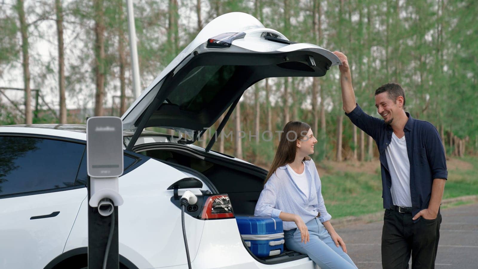 Couple recharge their EV car with electric battery charging station. Exalt by biancoblue