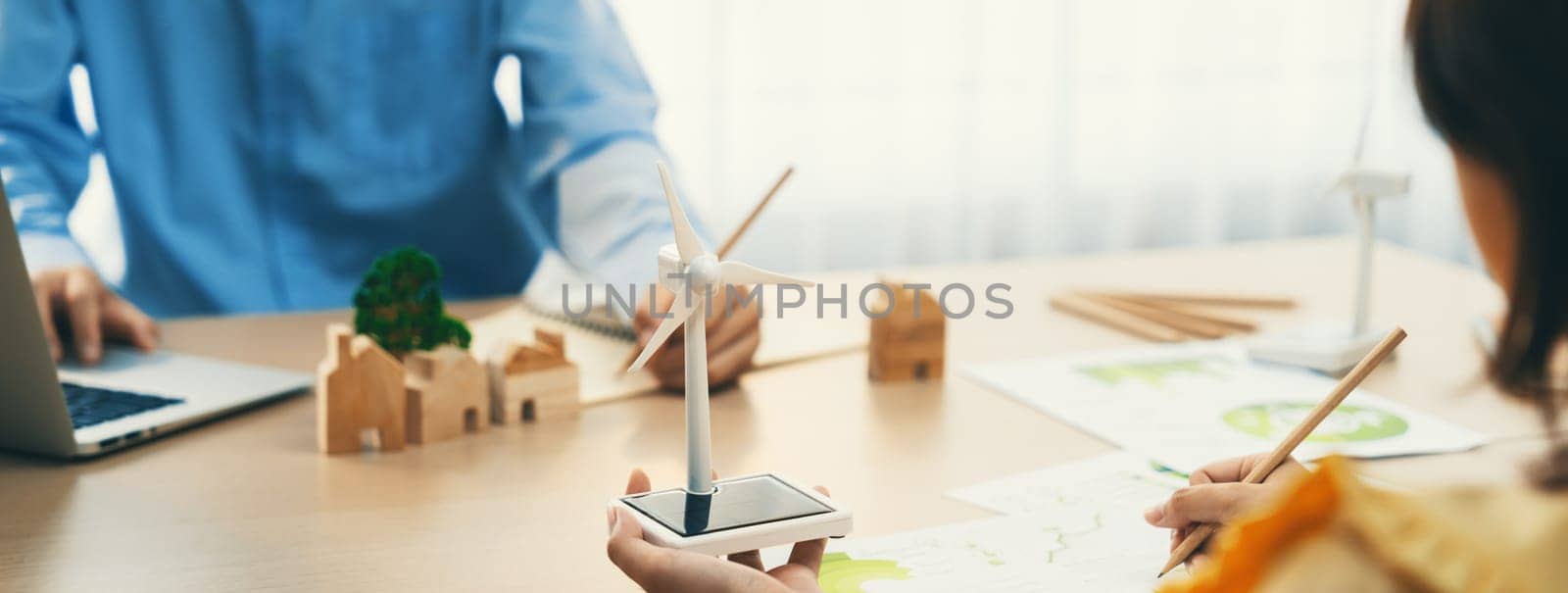 Businesswoman interested in investing in renewable energy at meeting table with environmental document scatter around. Business team discussion about green business project. Closeup. Delineation.