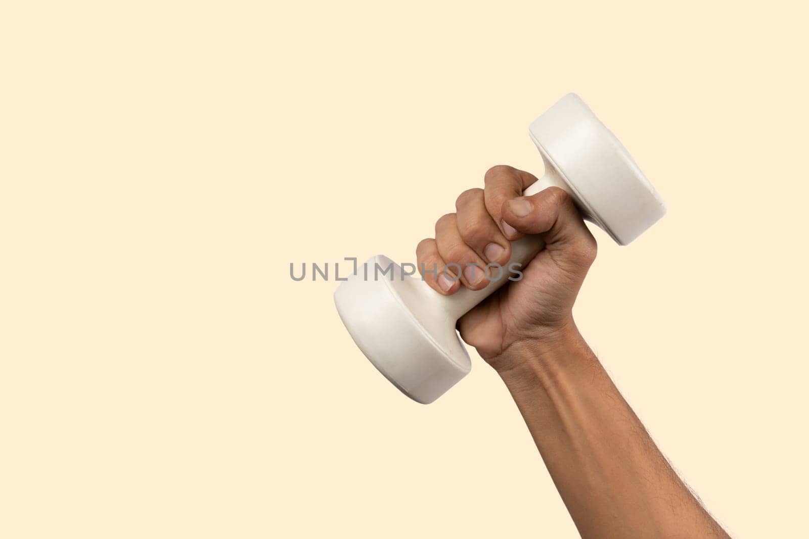 Black male hand holding a white dumbell isolated, light beige background by TropicalNinjaStudio