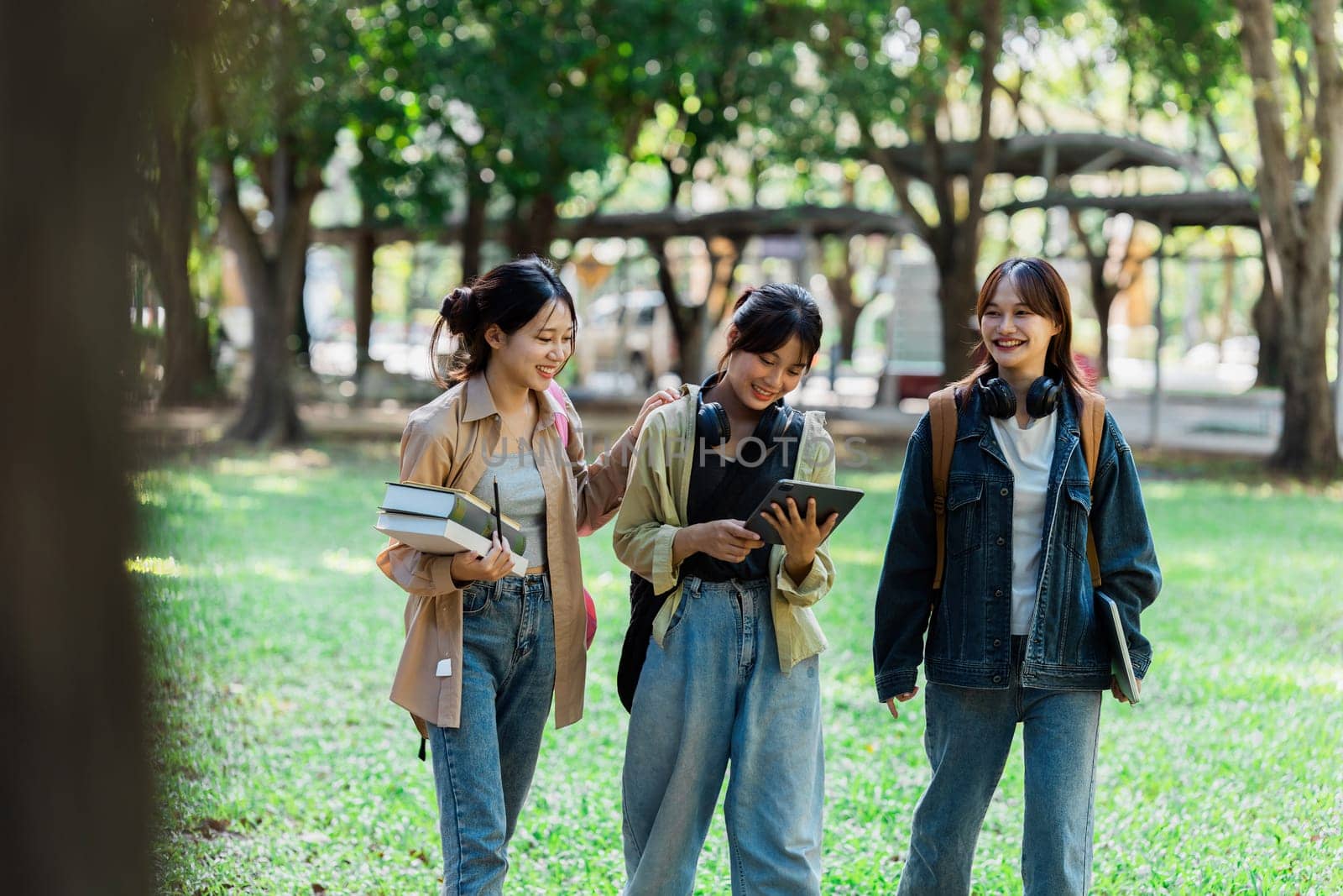 a group of young women are walking through a park . High quality