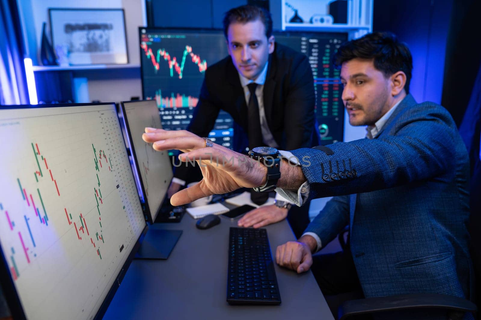 Stock exchange traders looking on high profit chart investment in panorama view, analyzing on monitor at night. Concept of discussing financial technology growth in neon light at workplace. Sellable.