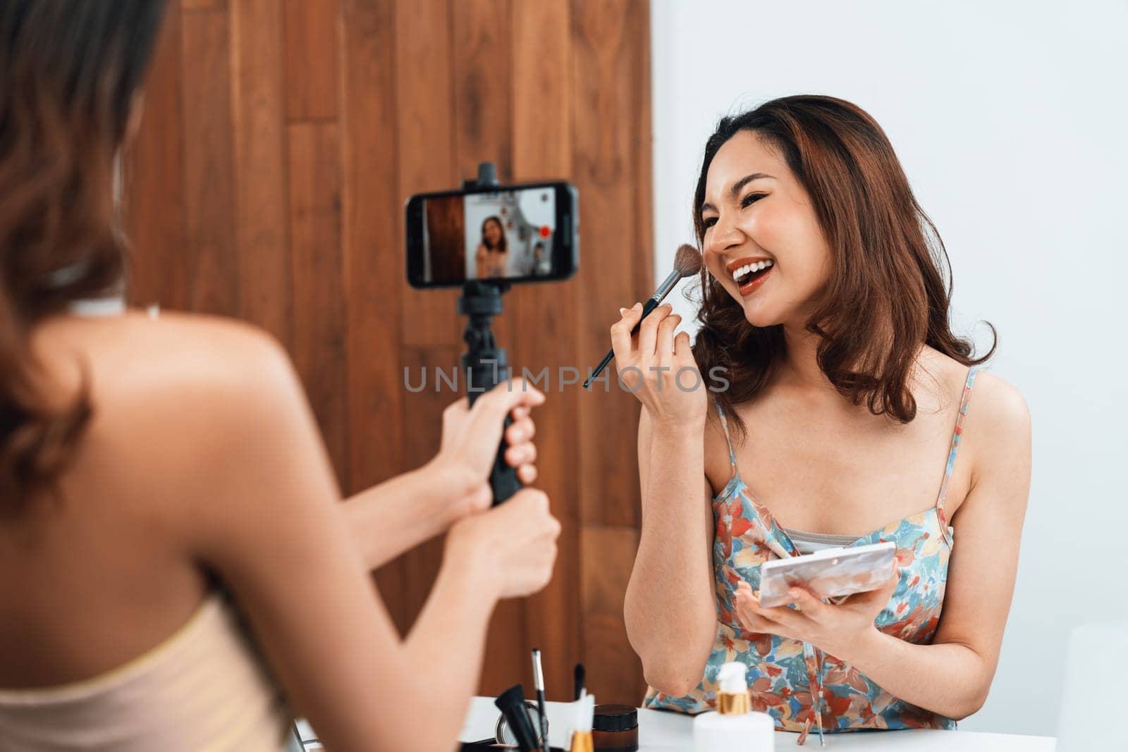 Woman influencer shoot live streaming vlog video review makeup uttermost social media or blog. Happy young girl with cosmetics studio lighting for marketing recording session broadcasting online.