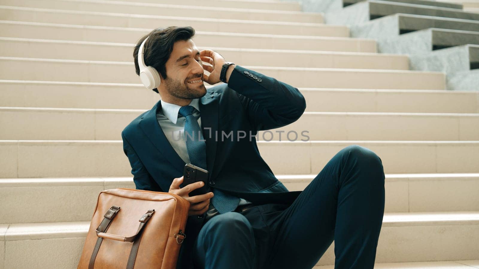 Smart business man listening and enjoy music while wear headphone. Profession project manager smiling while getting good news, getting promotion, increasing sales. Relaxing man enjoy music. Exultant.