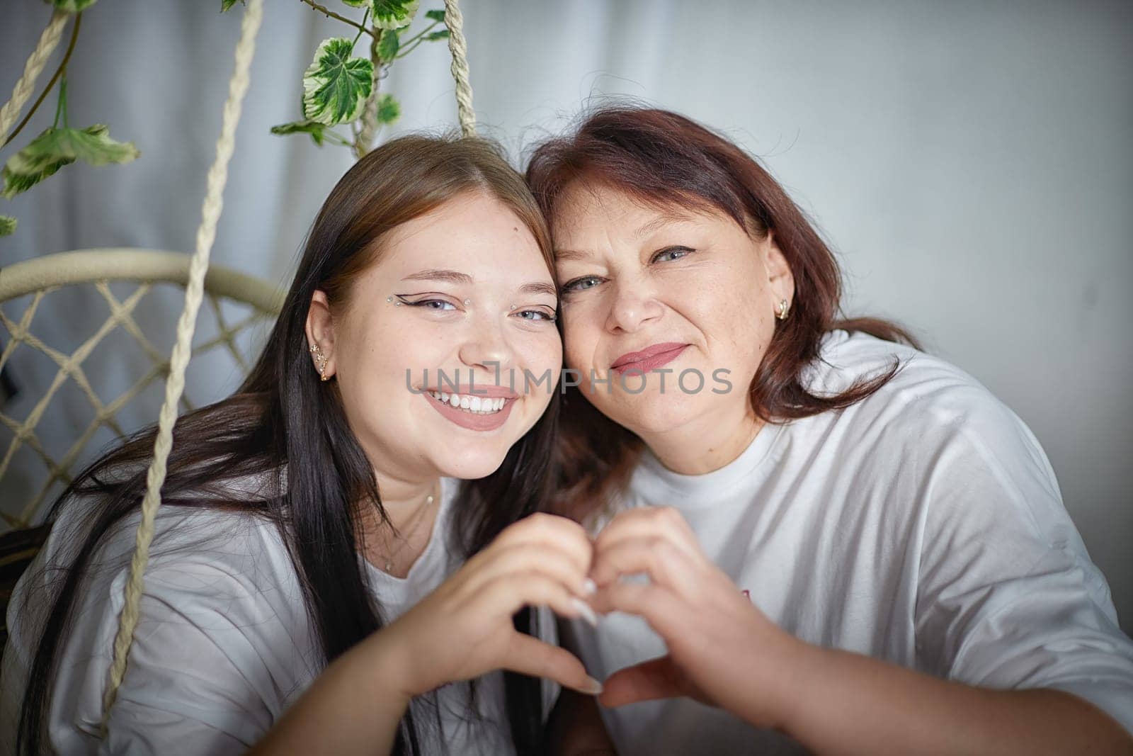 Happy Overweight family with mother and daughter in room. Middle aged woman and teenager girl having fun, joy, hugging by keleny