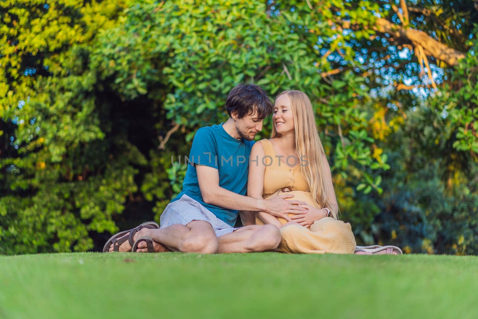 Pregnant woman and her husband spend quality time together outdoors, savoring each other's company and enjoying the serenity of nature by galitskaya